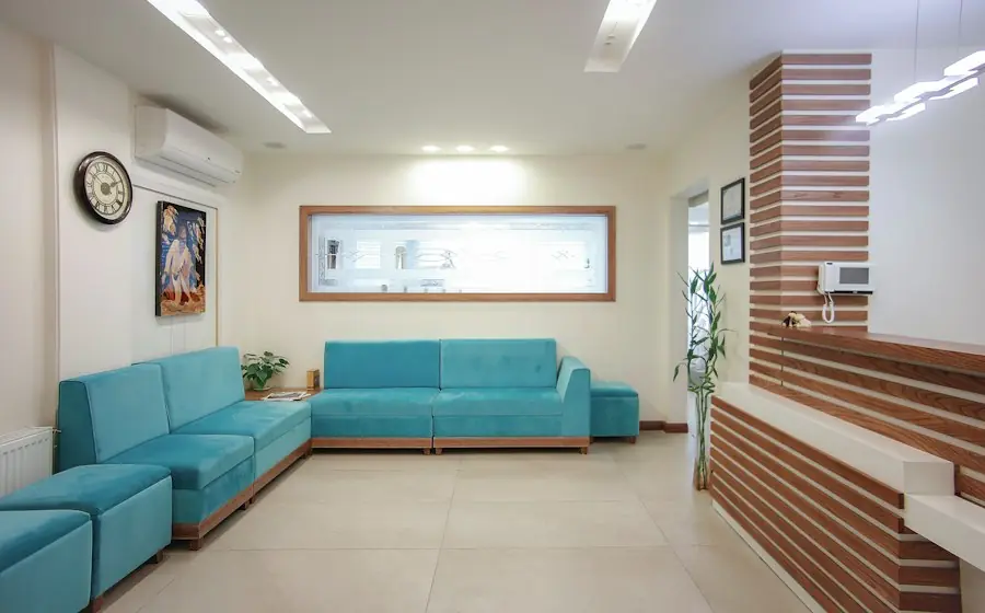 A clean hospital waiting area with a teal sofa